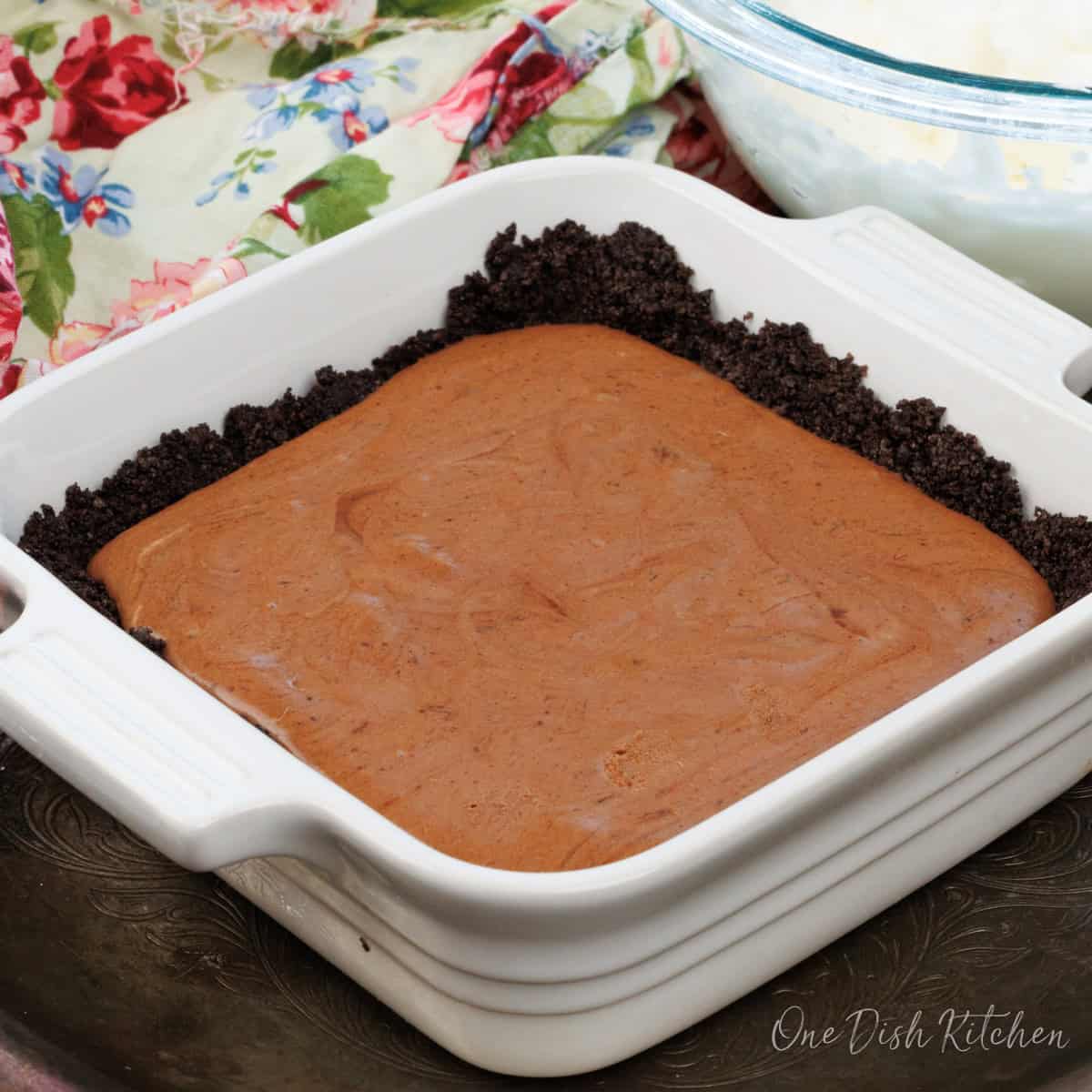 a mini french silk pie next to a bowl of whipped cream.