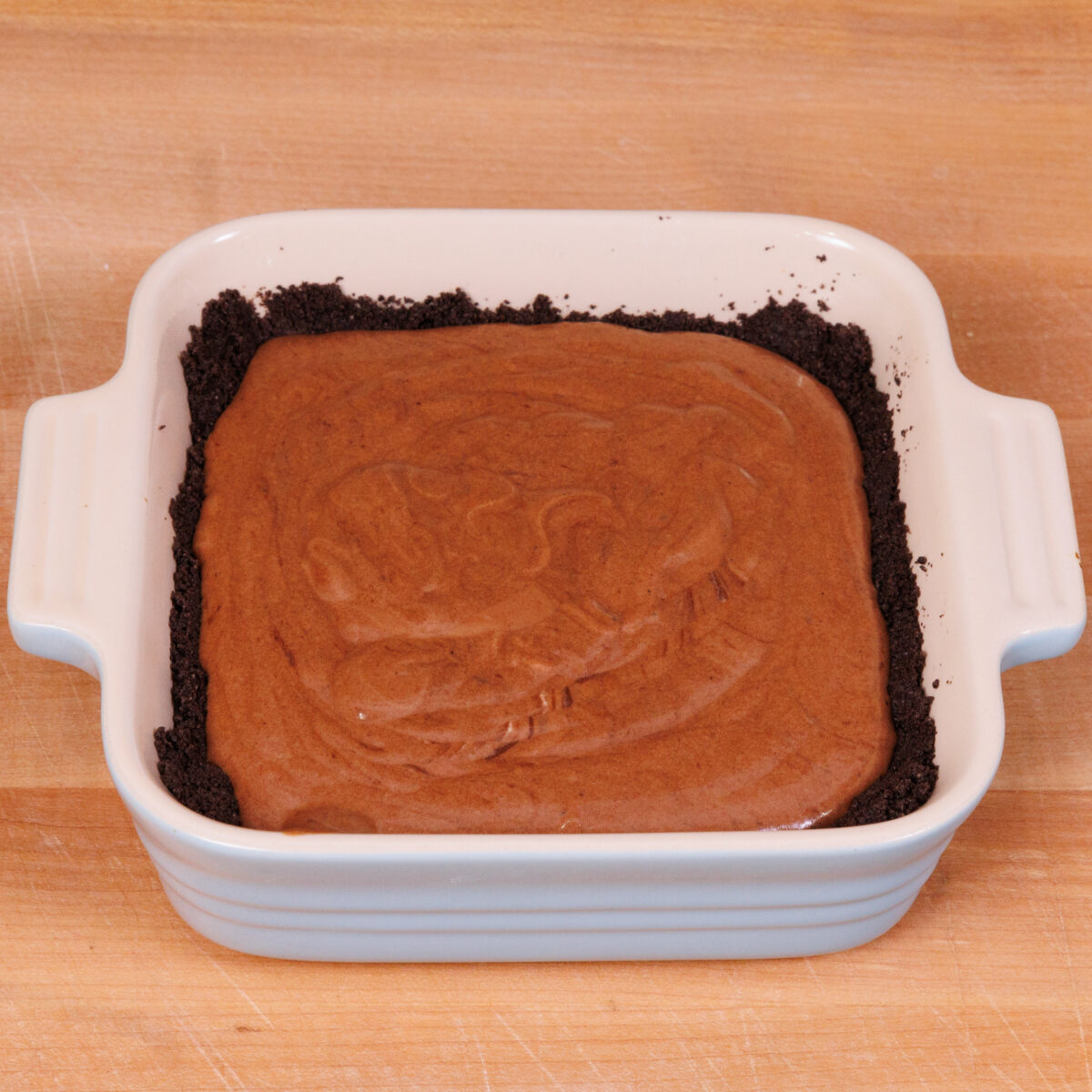 chocolate pudding over an oreo cookie crust in a small baking dish