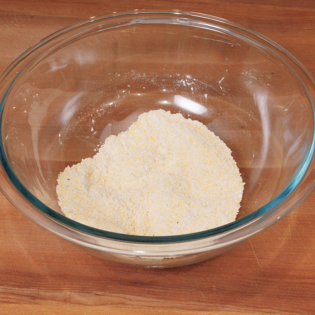 cornmeal, flour, sugar, and other ingredients needed to make hush puppies in a mixing bowl.