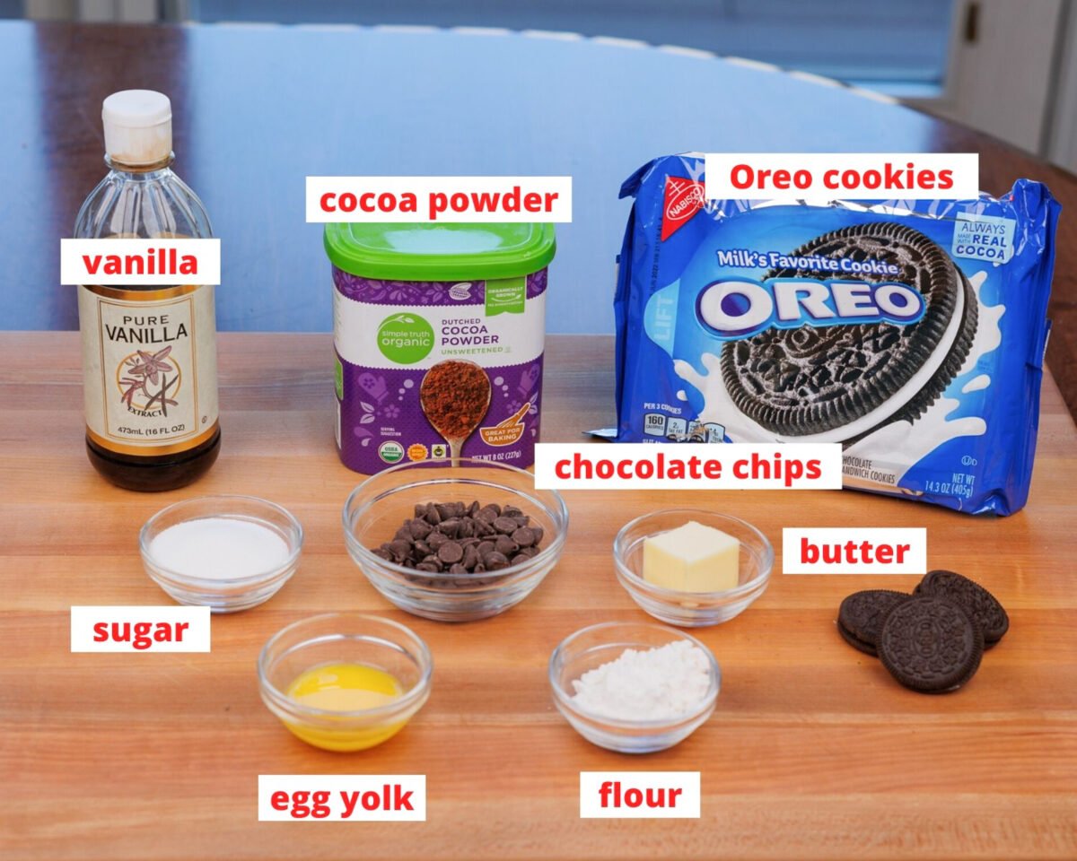 ingredients needed to make oreo brownies on a wooden cutting board.
