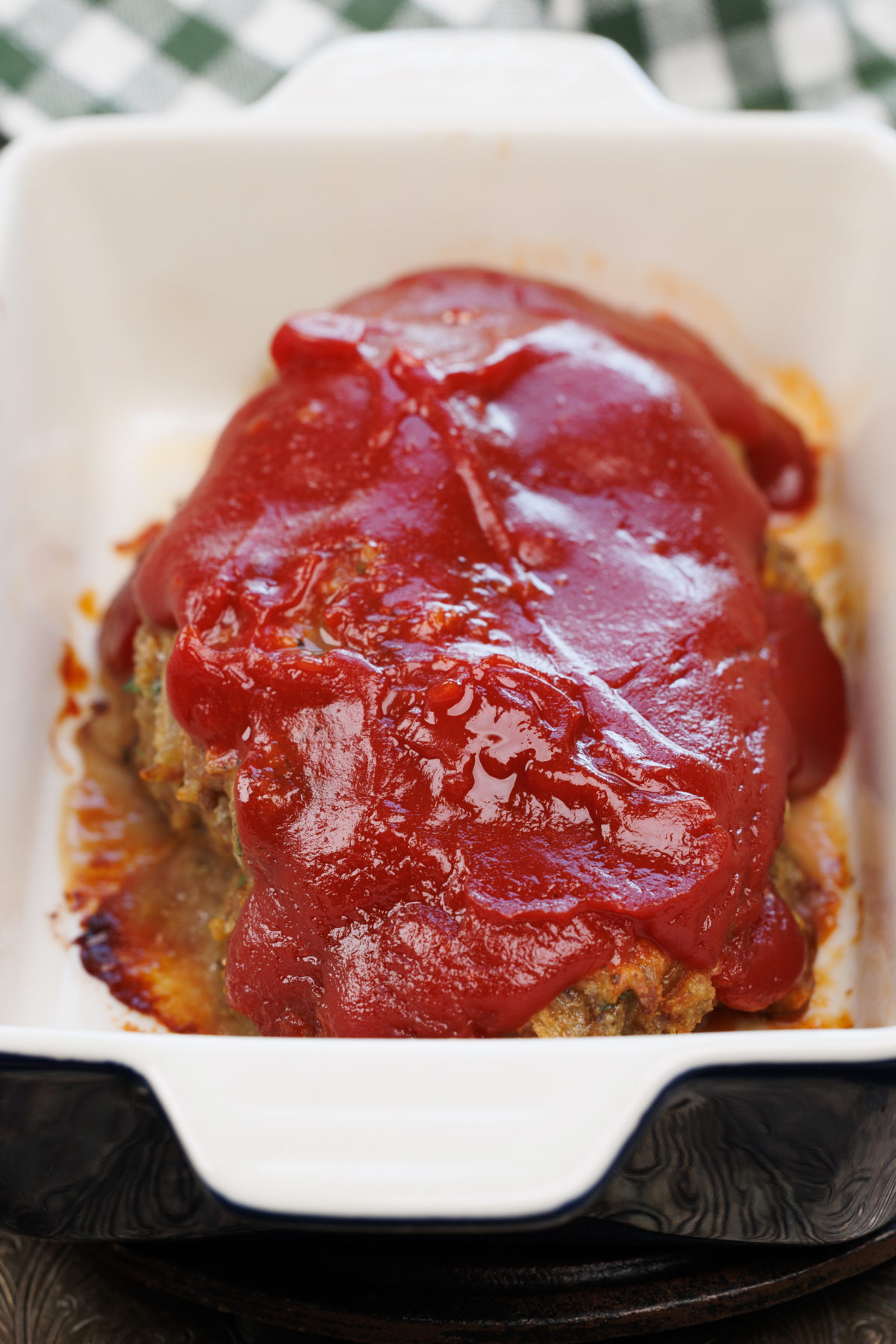 a mini meatloaf in a small baking dish on a wooden counter.