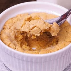 a single serve peanut butter cookie in a ramekin with a spoon on the side.
