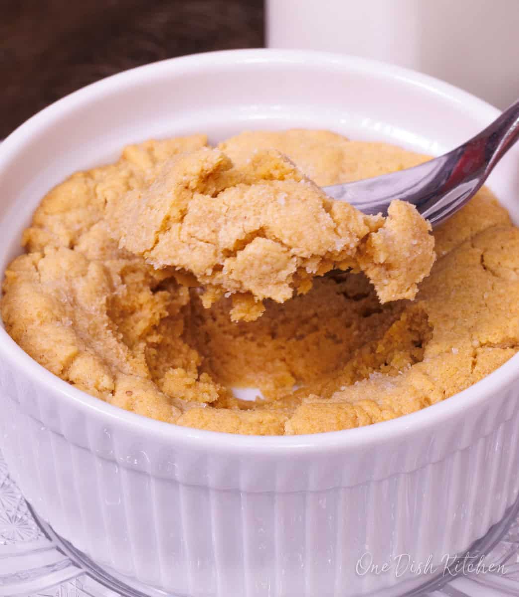 a single serve peanut butter cookie in a ramekin with a spoon on the side.