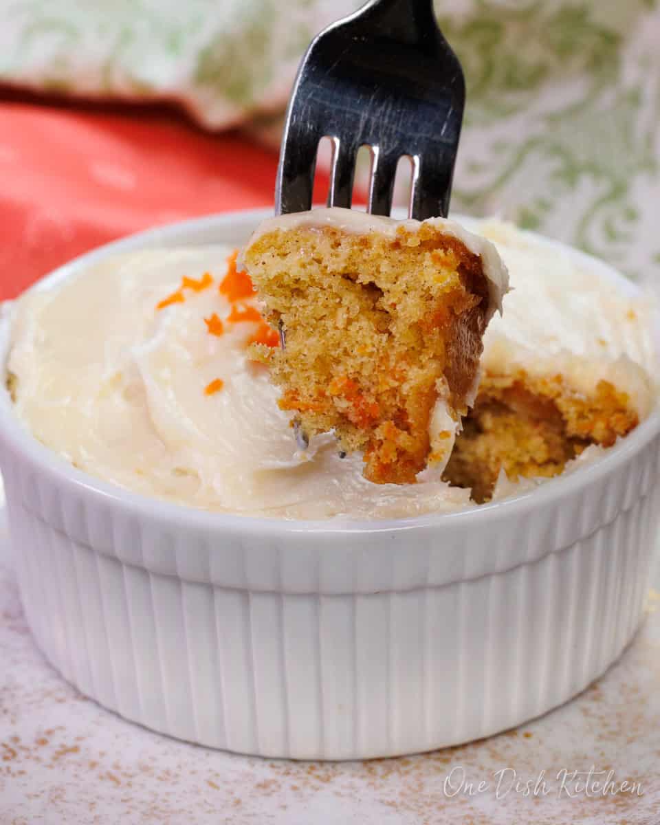 a small frosted carrot cake with a fork on the side.