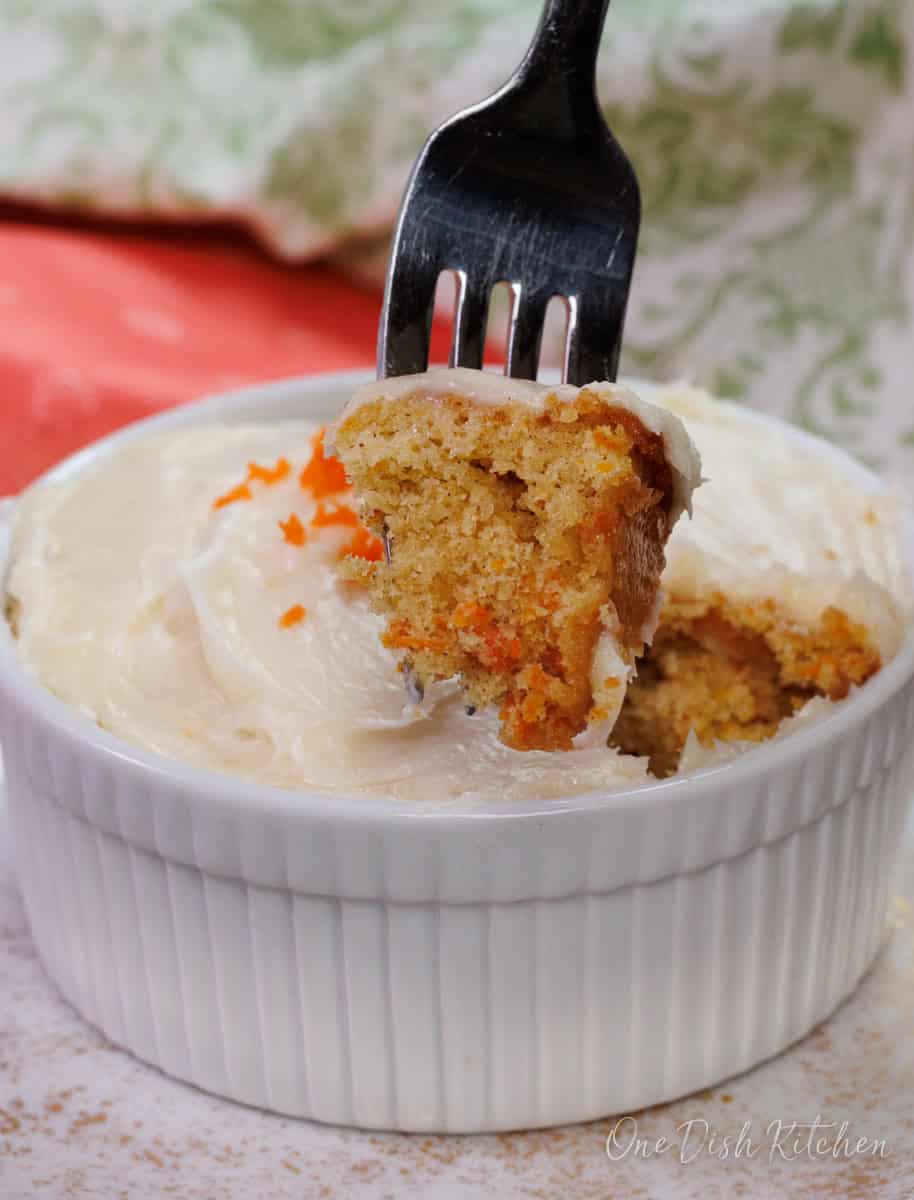 a small frosted carrot cake with a fork on the side.