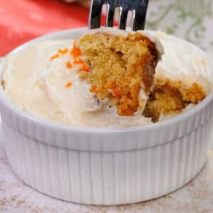 a small frosted carrot cake with a fork on the side.