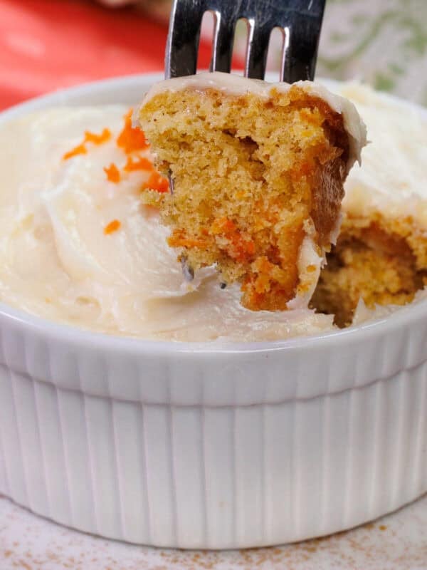 a small frosted carrot cake with a fork on the side.