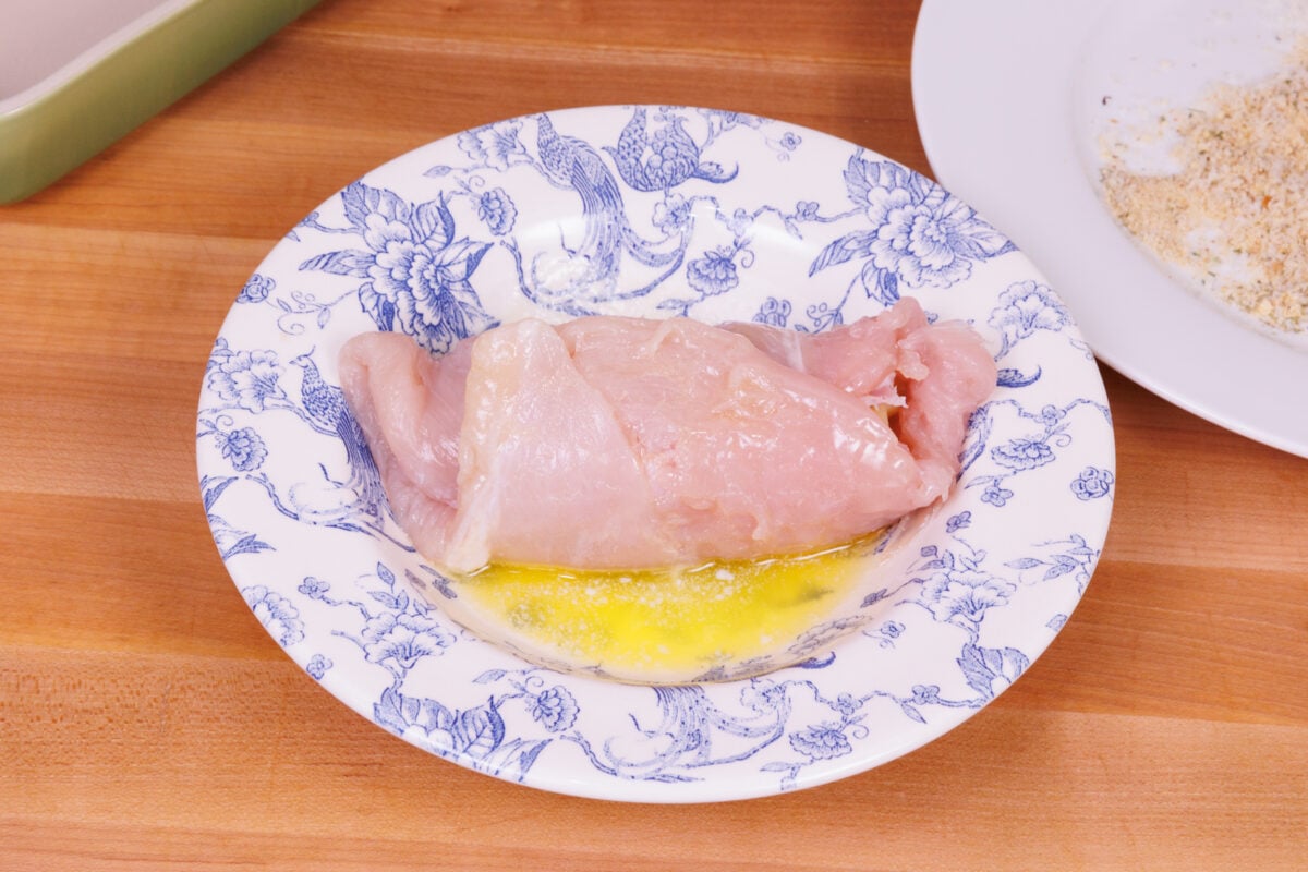 dipping chicken into melted butter when making chicken cordon bleu.