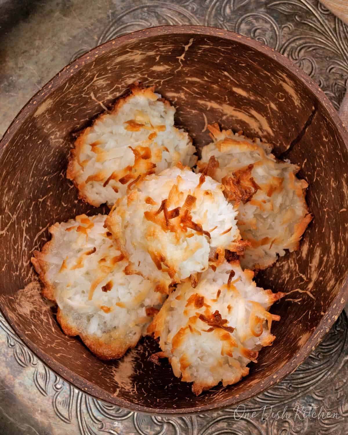 a small batch of coconut macaroons in a brown bowl.