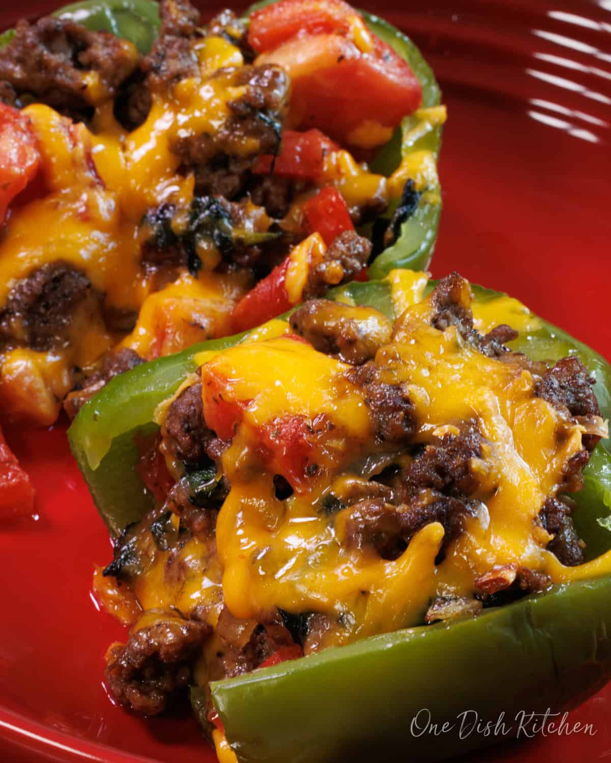 two stuffed bell peppers in a baking dish.