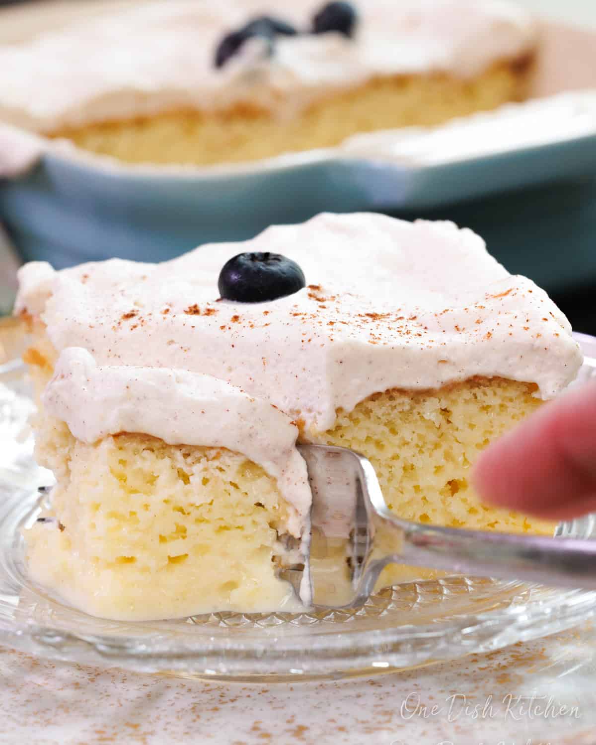 a fork scooping up a bite of tres leches cake.
