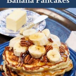 three banana pancake on a blue plate topped with banana slices and pecans.