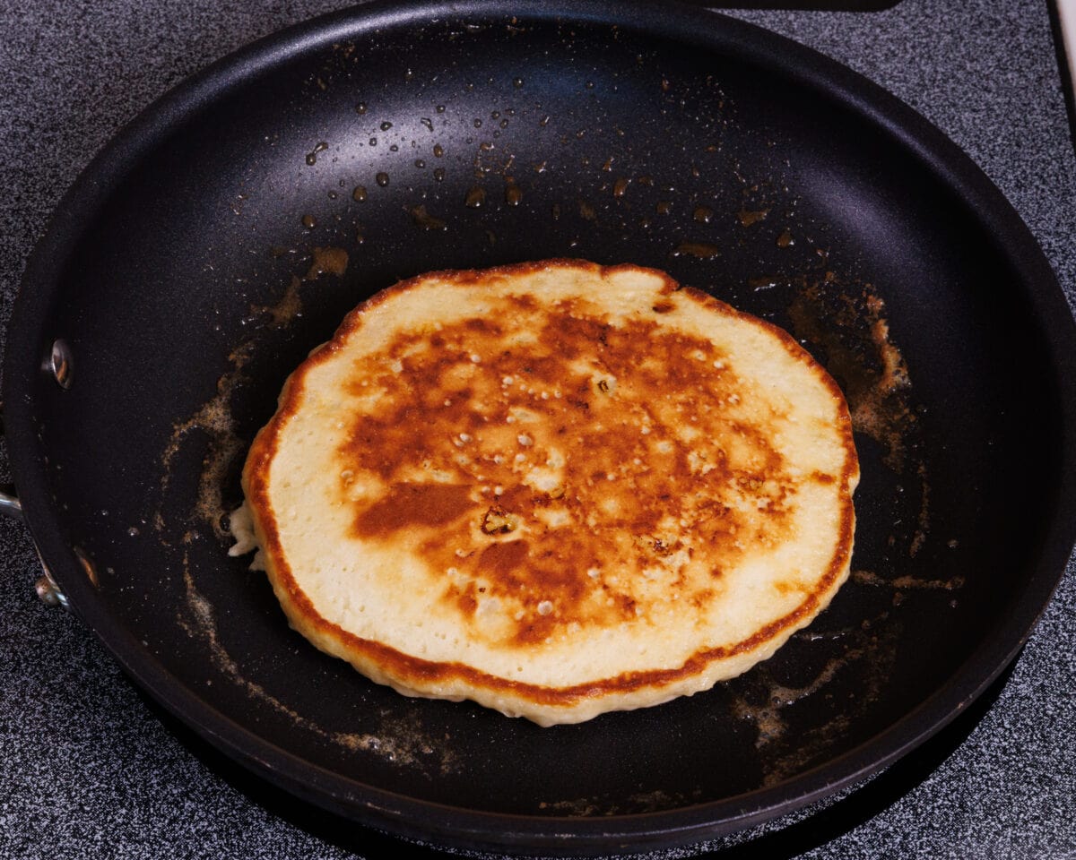 one pancake cooking in a skillet.