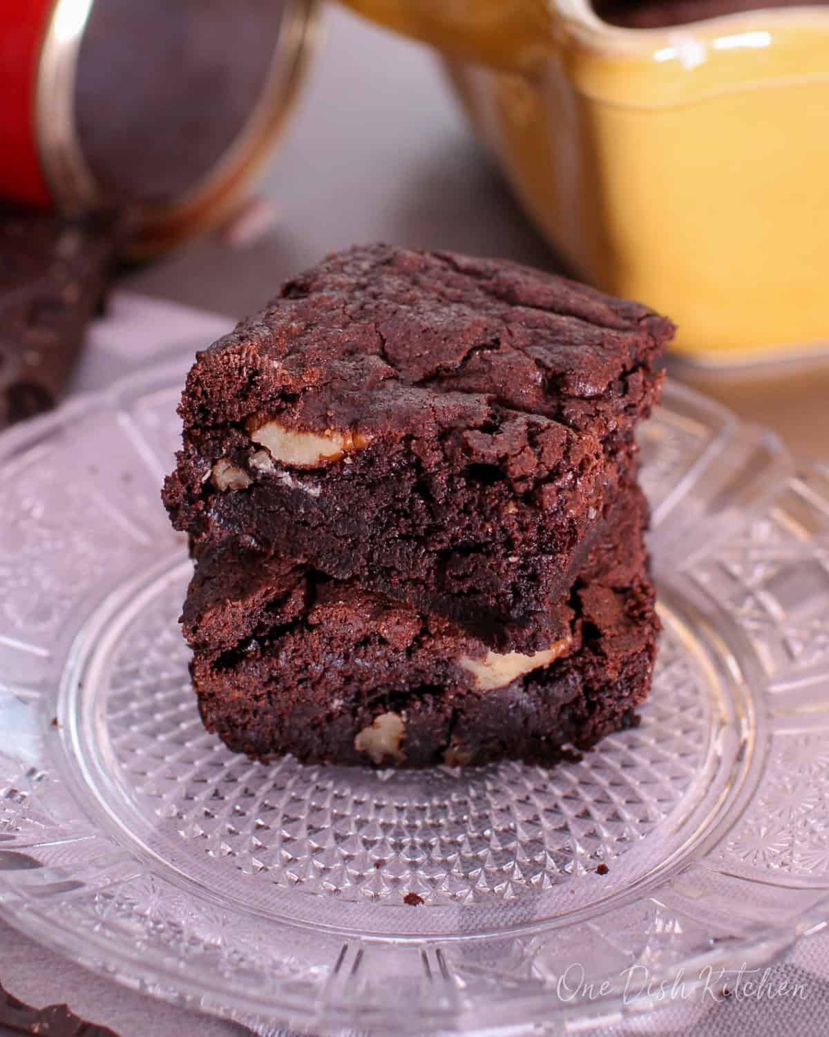 a small batch of brownies on a plate stacked on top of each other.