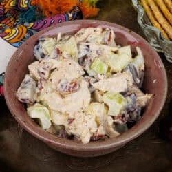 a small batch of chicken salad made with cooked chicken in a pink bowl.