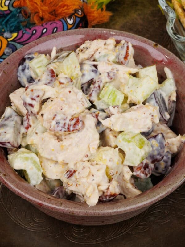 a small batch of chicken salad made with cooked chicken in a pink bowl.