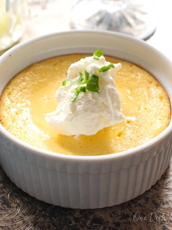a mini key lime pie on a silver tray topped with whipped cream.