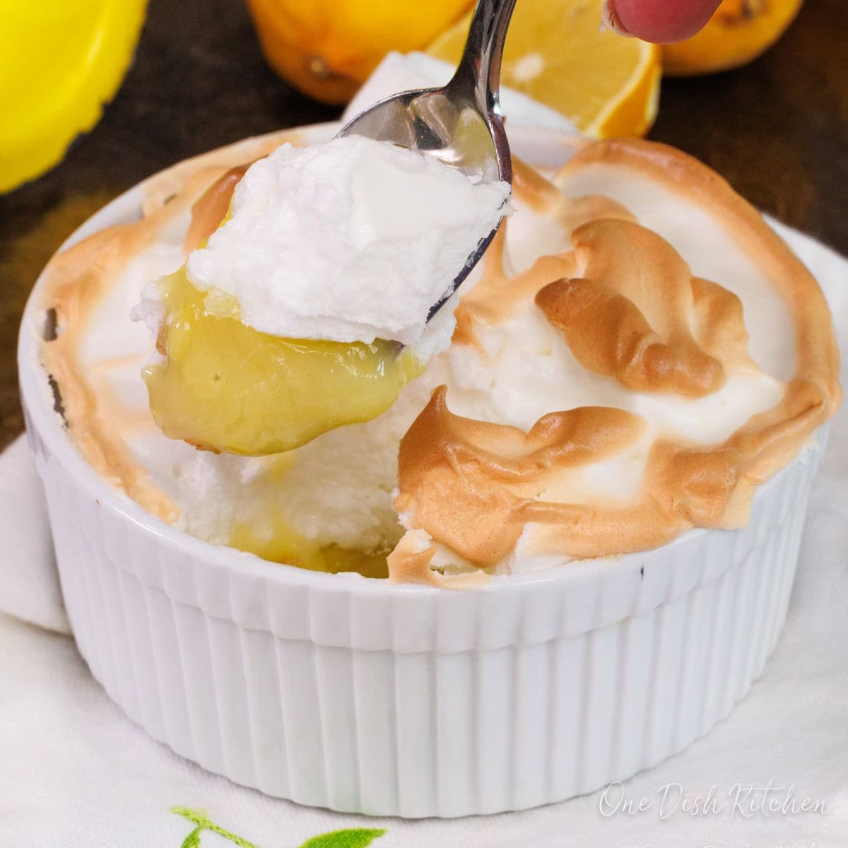 a spoon holding a bite of lemon meringue pie.