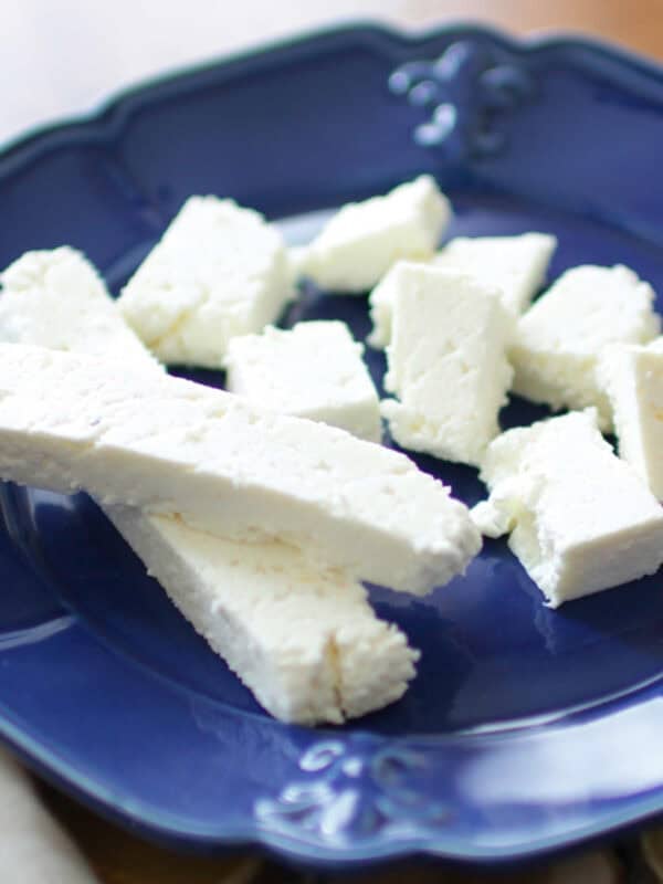 cubes of paneer on a blue plate.