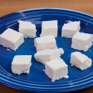 cubes of paneer on a blue plate.