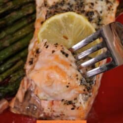 baked salmon on a fork next to roasted asparagus.