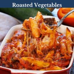 a roasted vegetable pasta bake in a red baking dish.