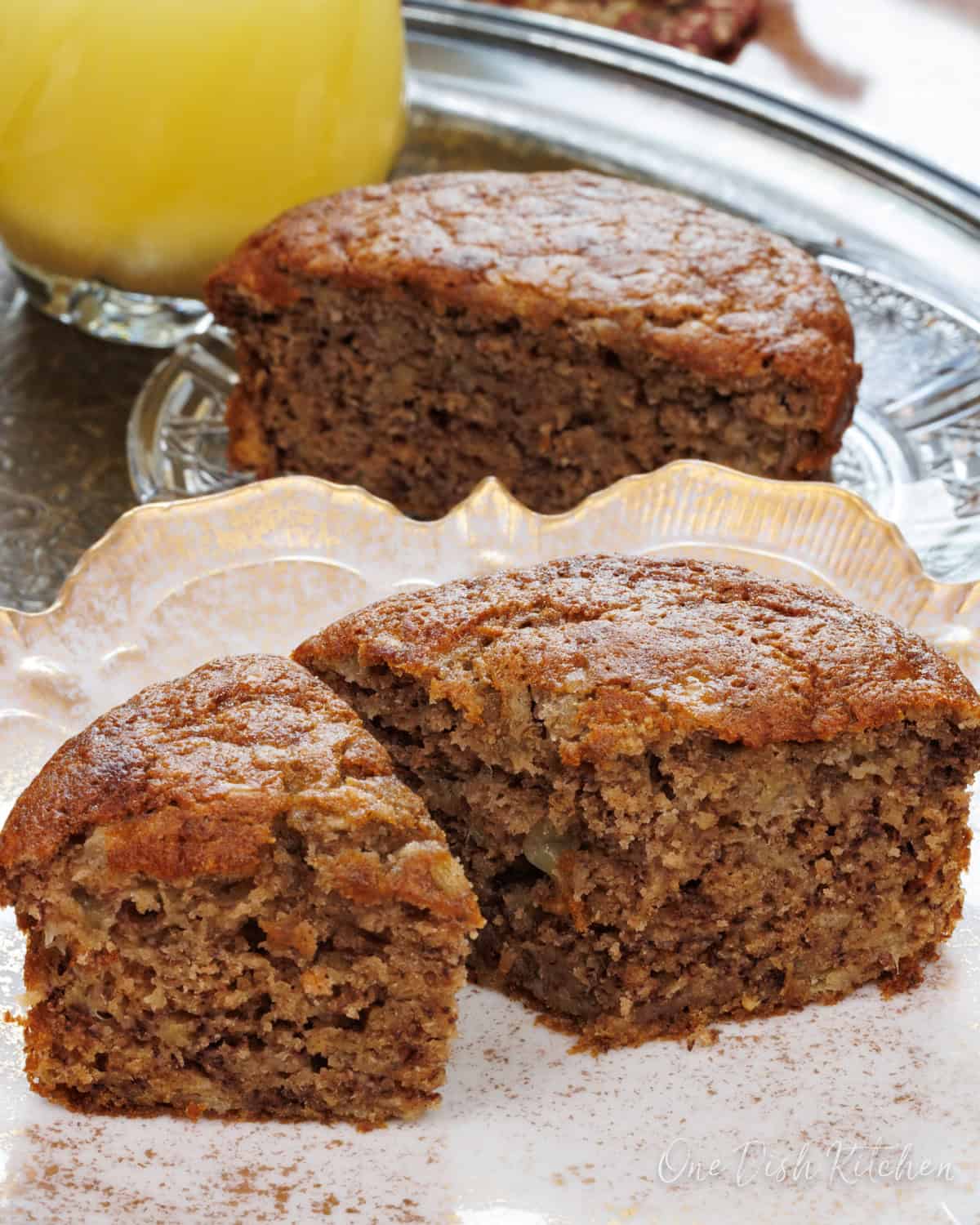 a small loaf of banana bread sliced in half on a plate.