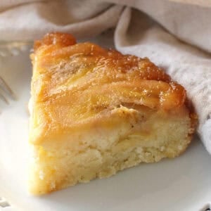 a slice of caramelized banana upside down cake on a white plate.