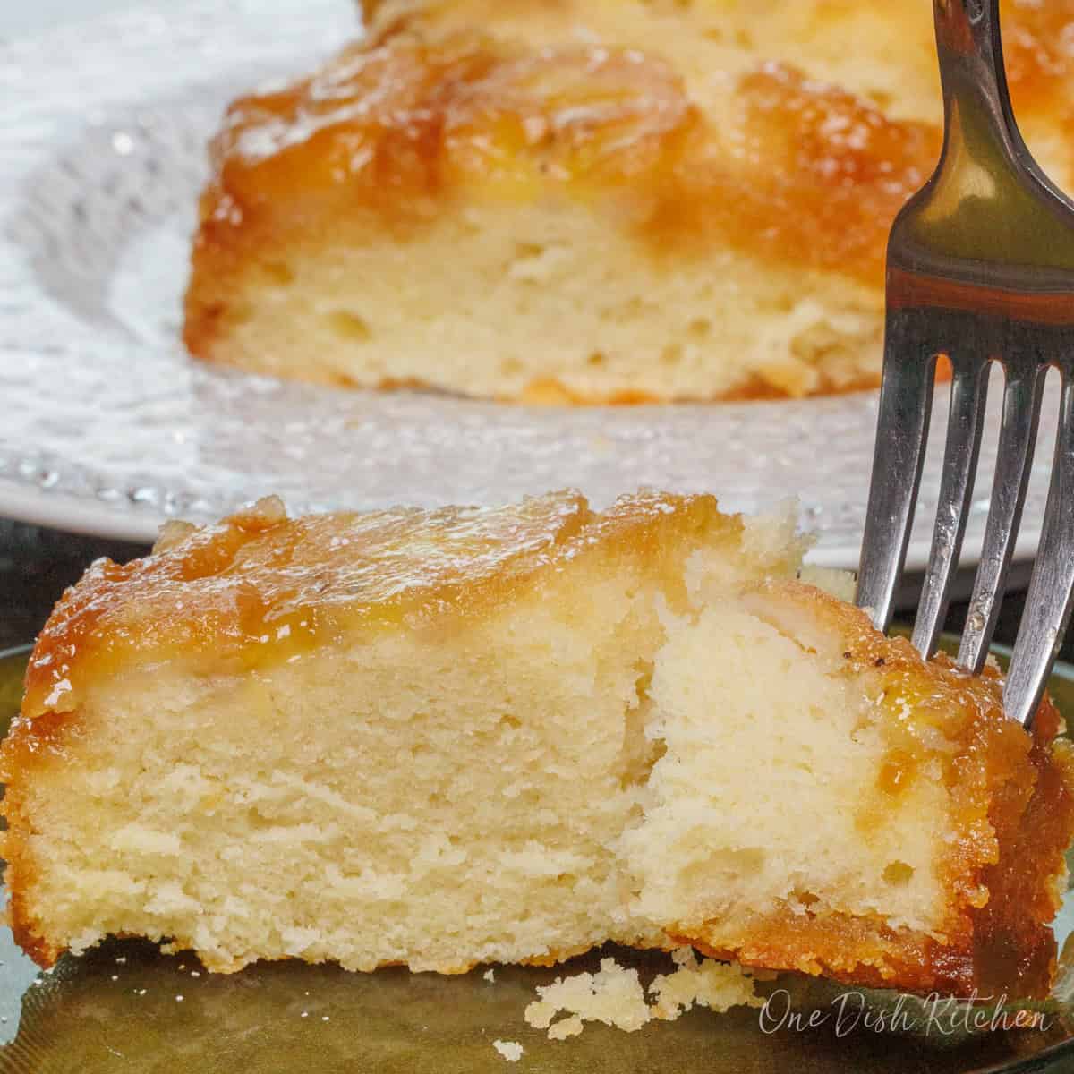 a slice of banana upside down cake on a plate with a fork on the side.