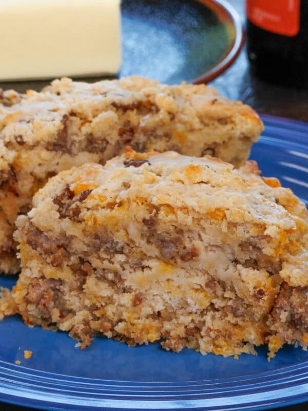 a small beer bread on a blue plate next to a bottle of beer.