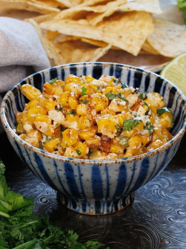 a bowl of mexican street corn dip on a blue bowl