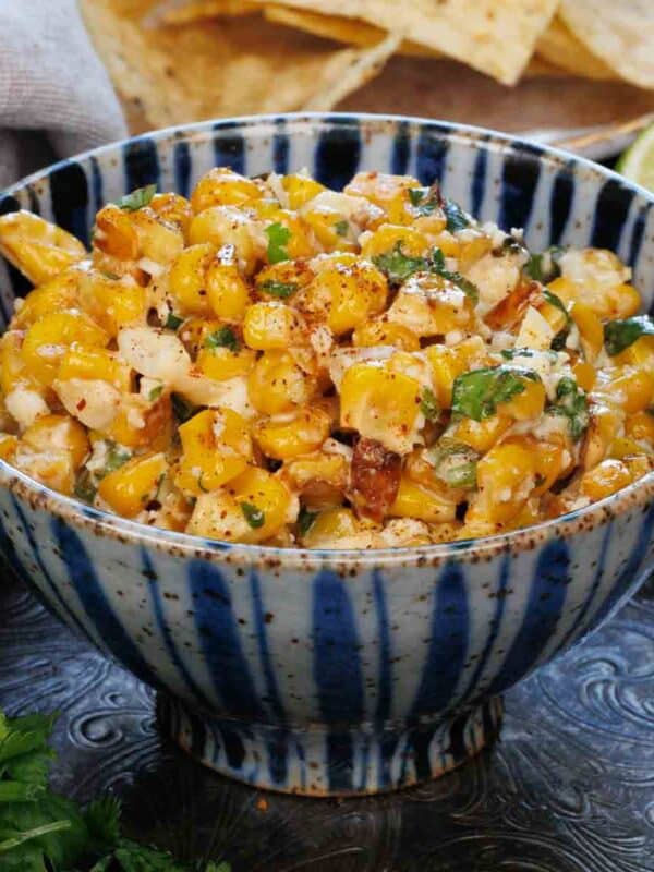 a bowl of mexican street corn dip on a blue bowl.