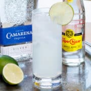 a highball glass filled with ranch water next to a lime