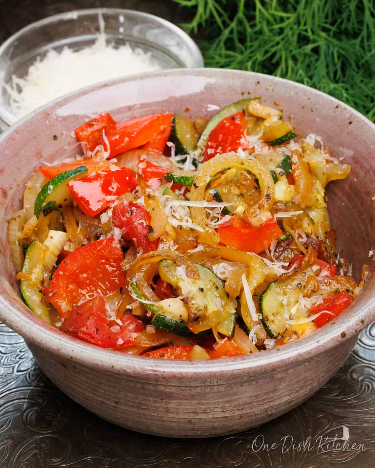 a single serving ratatouille in a bowl made with fresh red bell peppers, onions, and zucchini.
