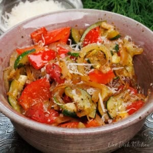 a single serving ratatouille in a bowl made with fresh red bell peppers, onions, and zucchini.