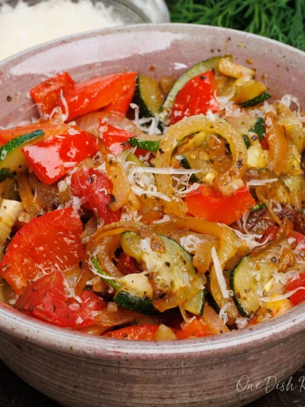 a single serving ratatouille in a bowl made with fresh red bell peppers, onions, and zucchini.