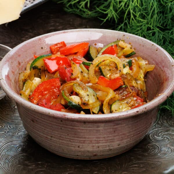 a bowl of ratatouille on a silver tray.