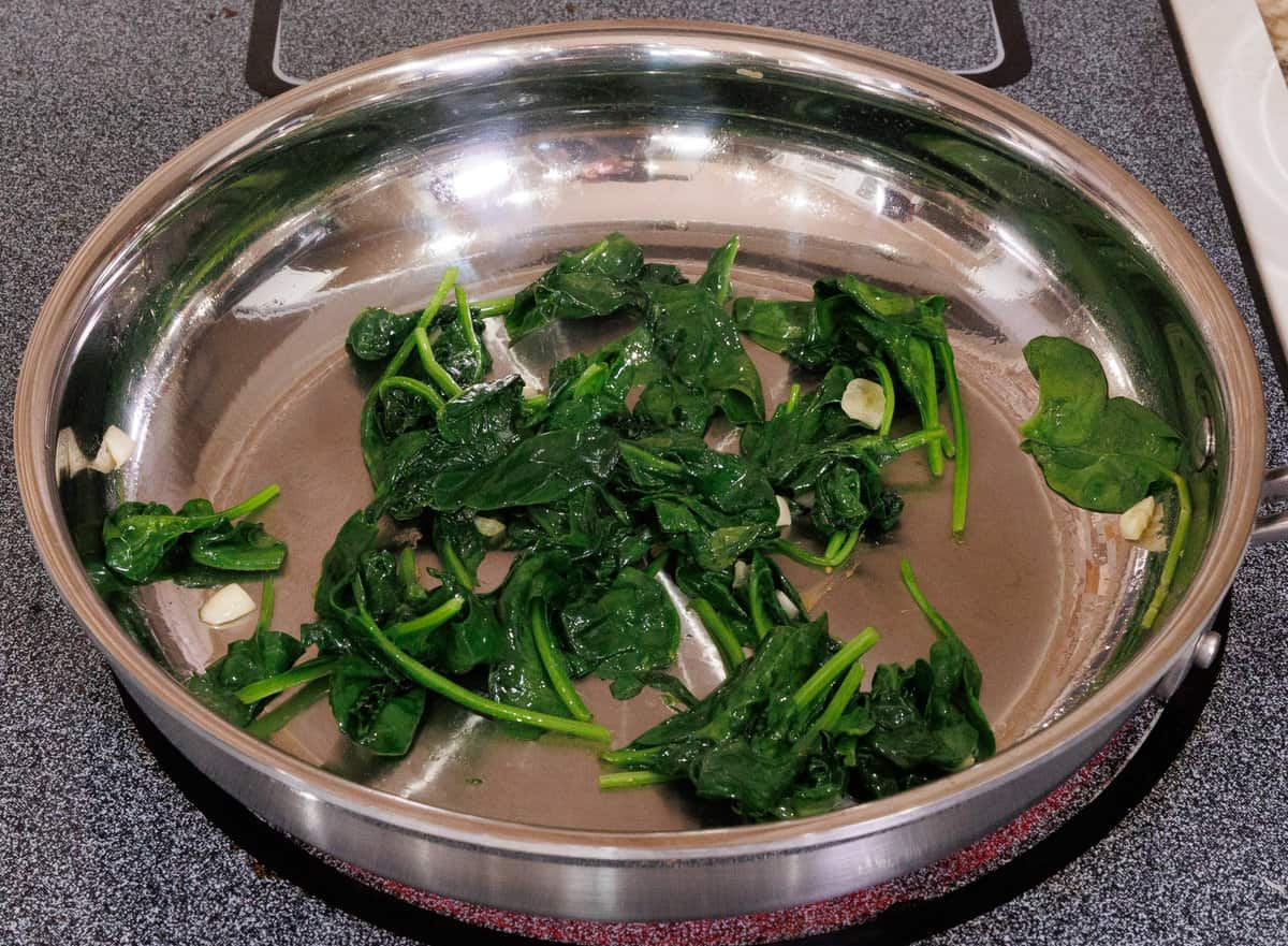 spinach cooking in a small skillet.
