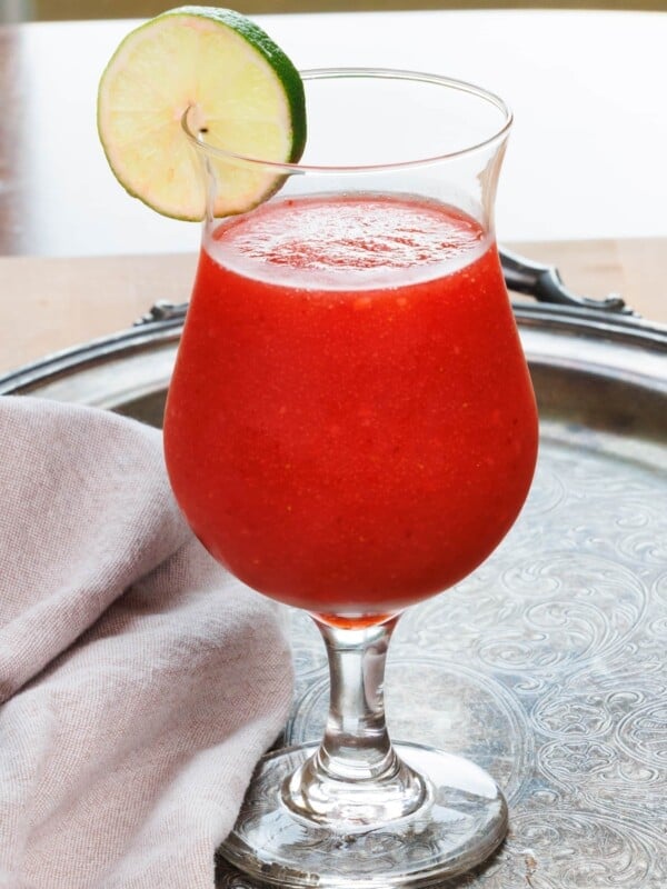 a strawberry daiquiri in a glass with a lime slice on the rim