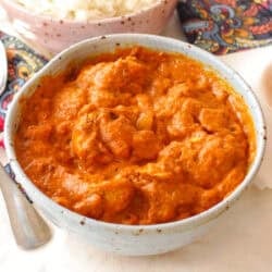 butter chicken in a small blue bowl.