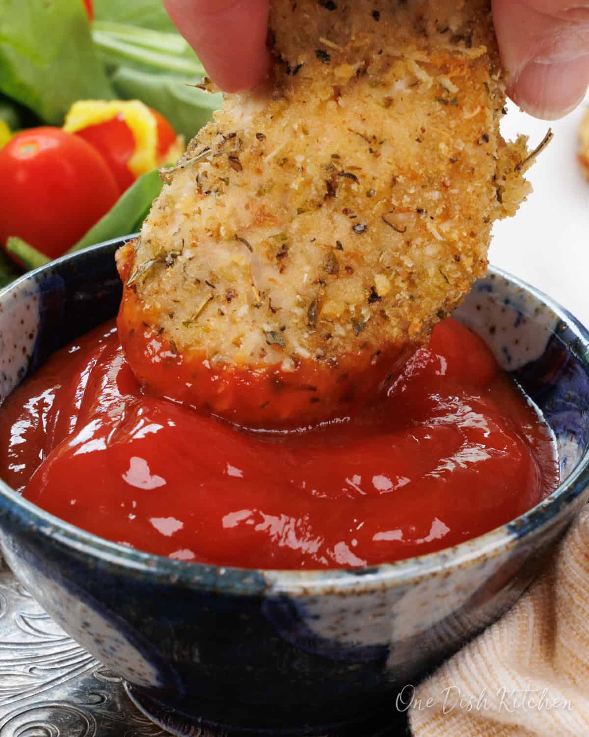 a single chicken tender in dipping sauce.