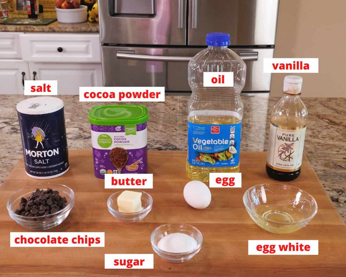 flourless chocolate cake ingredients on a wooden cutting board in a kitchen.