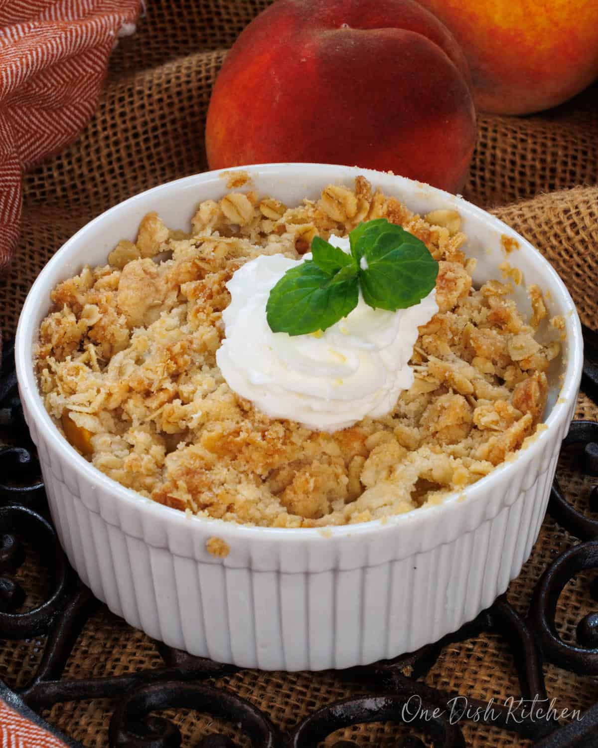 a small peach crisp next to two fresh peaches.