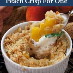 a small peach crisp with a spoon on the side.