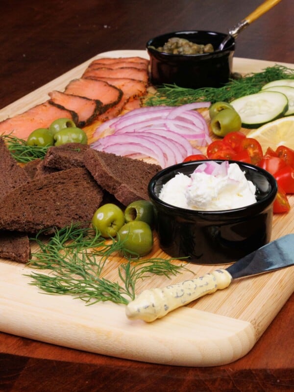 a smoked salmon grazing board on a brown wooden table
