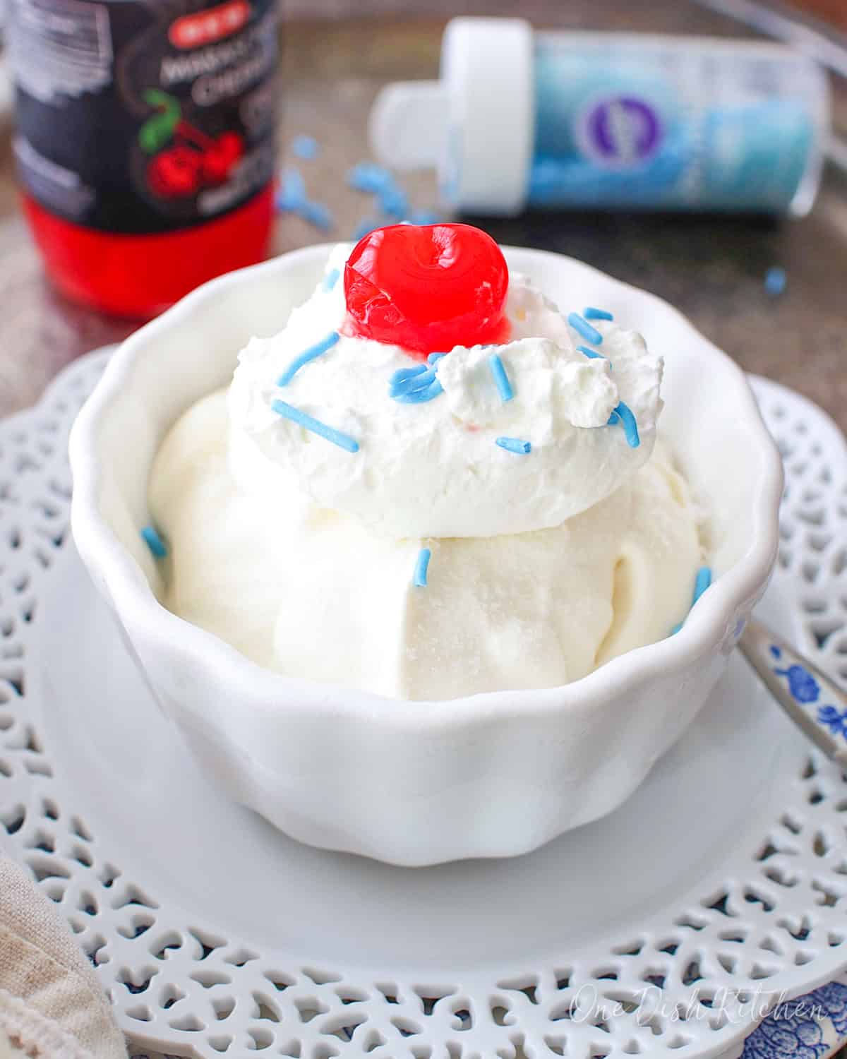 a single serving of vanilla ice cream in a bowl with a cherry on top.