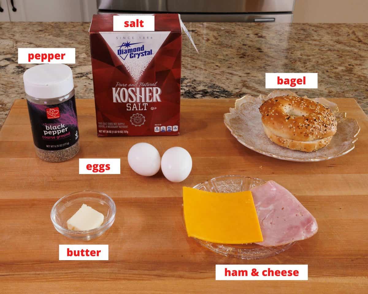 ingredients in a breakfast bagel sandwich on a kitchen counter.