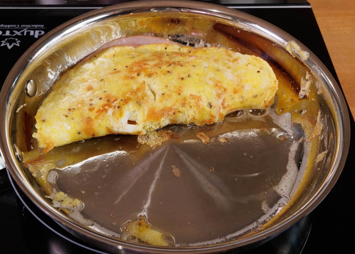 a ham and cheese omelet in a skillet.