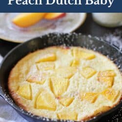 a small dutch baby with peaches in a cast iron skillet.