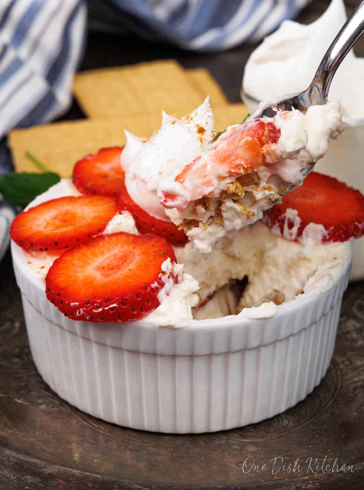 a small strawberry icebox cake with a spoon on the side holding some of the cake.